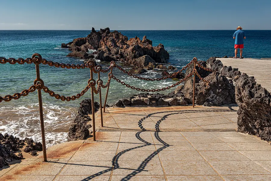 Rocky shore and chain railing by the promenade near Playa Chica, Puerto del Carmen